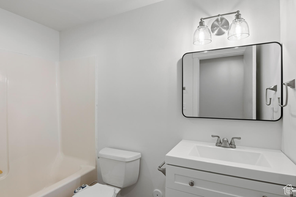 Full bathroom featuring vanity, toilet, and  shower combination