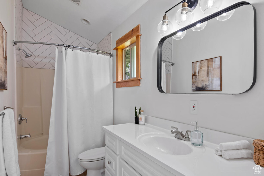 Full bathroom featuring toilet, shower / tub combo, and oversized vanity