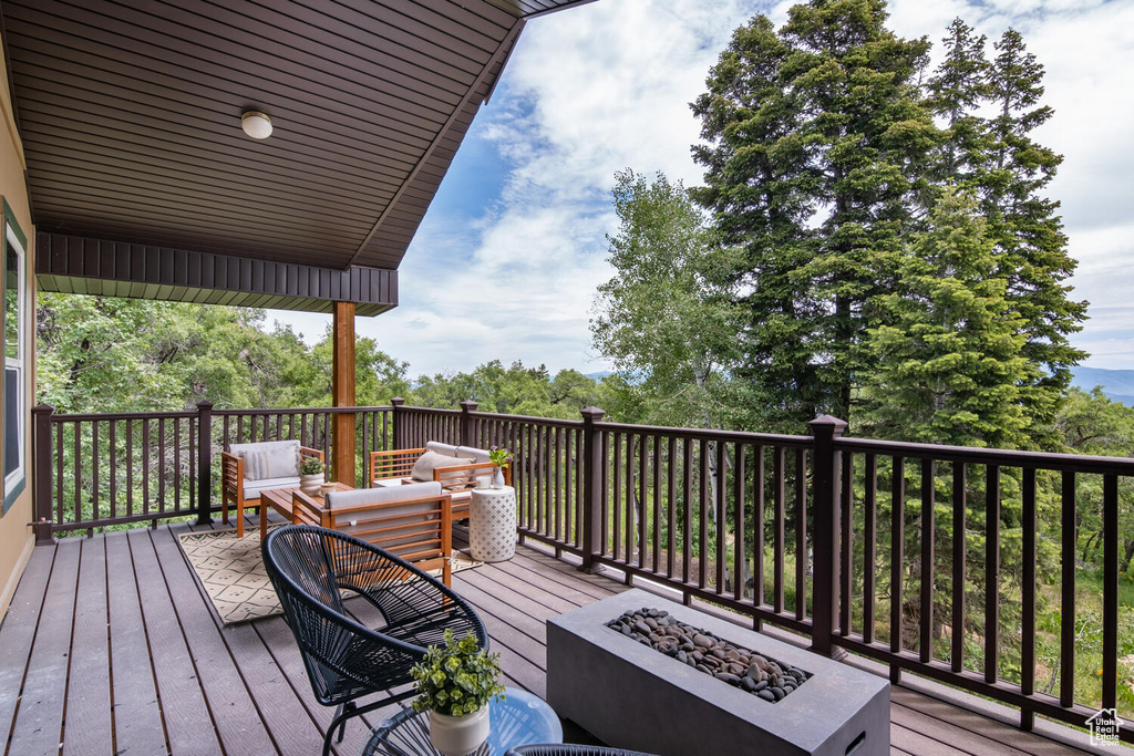 Deck with an outdoor living space with a fire pit