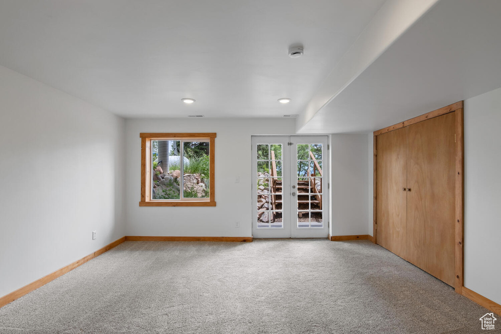 Unfurnished bedroom featuring french doors and carpet