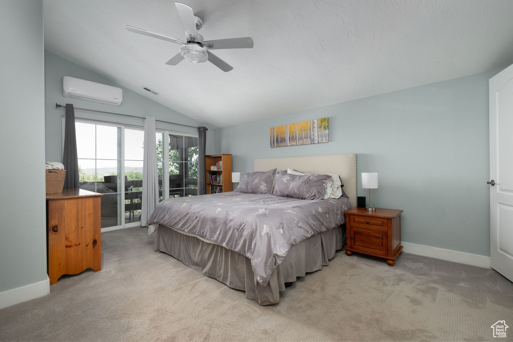 Carpeted bedroom featuring ceiling fan, vaulted ceiling, access to exterior, and a wall mounted AC