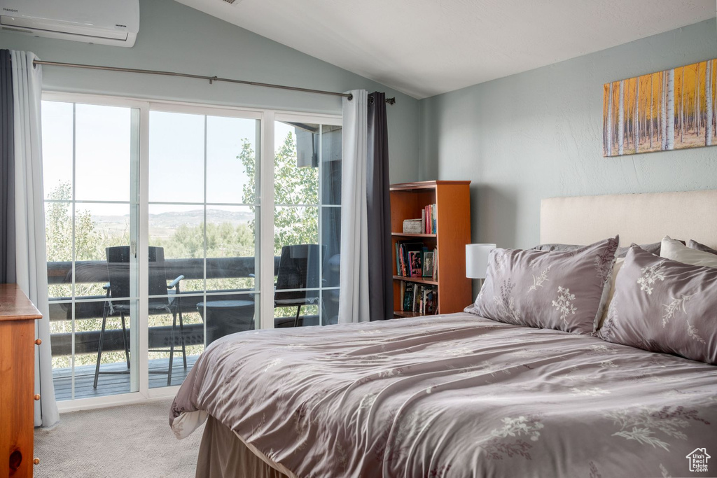 Bedroom with access to outside, carpet flooring, vaulted ceiling, and an AC wall unit