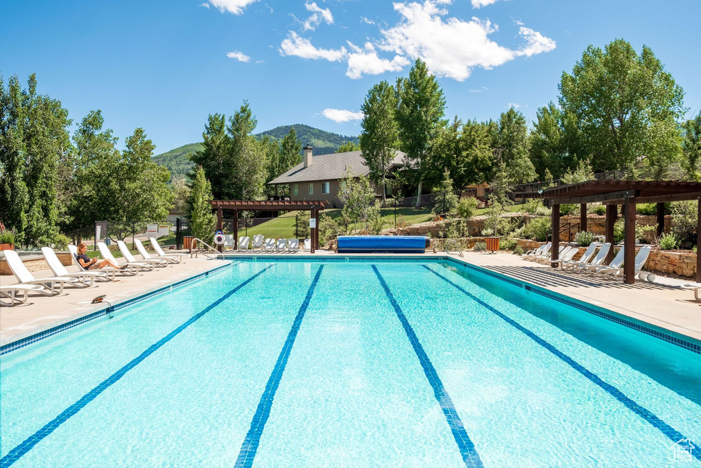 View of swimming pool featuring a pergola, a patio, and a mountain view