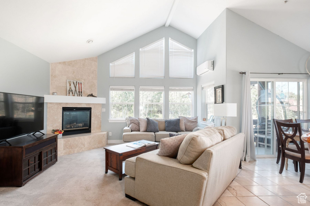 Living room with a high end fireplace, beamed ceiling, a wall mounted AC, high vaulted ceiling, and light tile floors