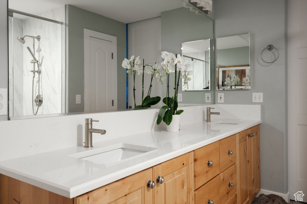 Bathroom featuring double vanity and a shower with door