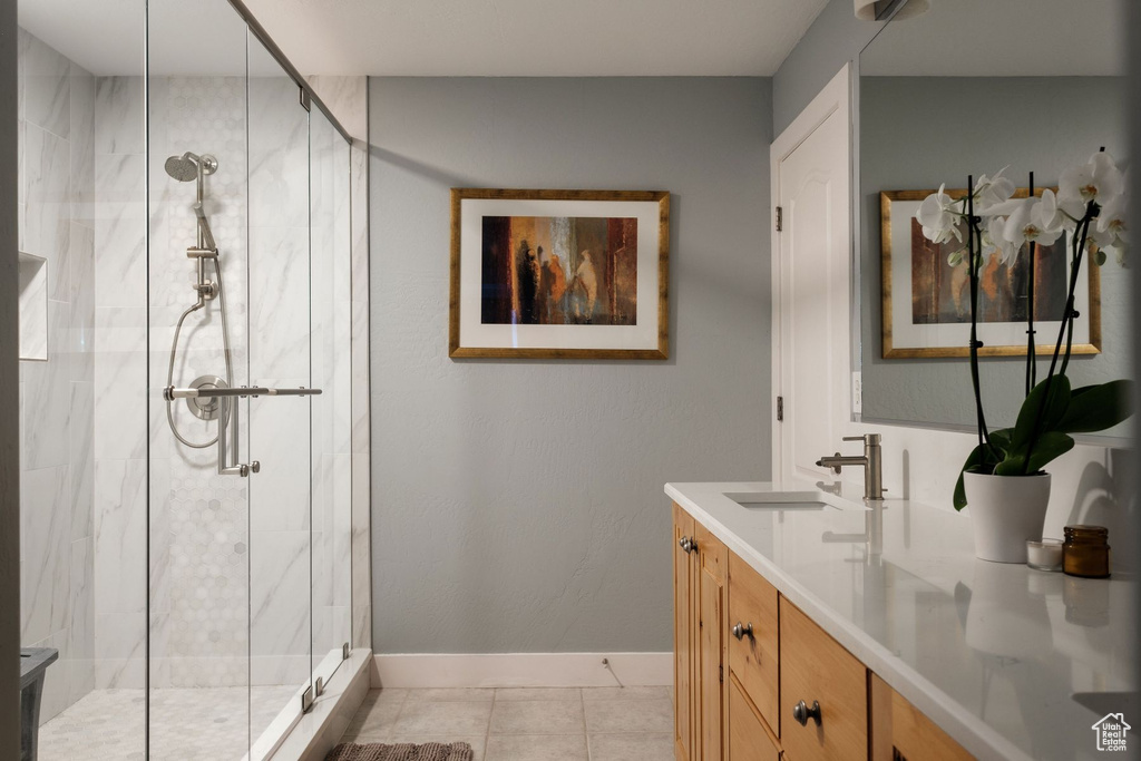 Bathroom with vanity, tile floors, and a shower with door