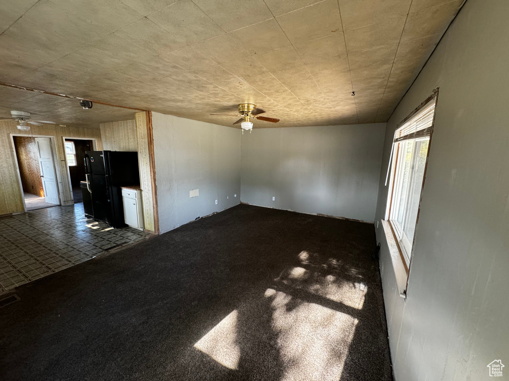 Carpeted spare room featuring ceiling fan