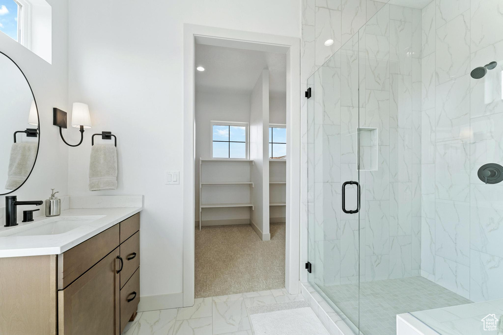 Bathroom with tile floors, a shower with door, and vanity