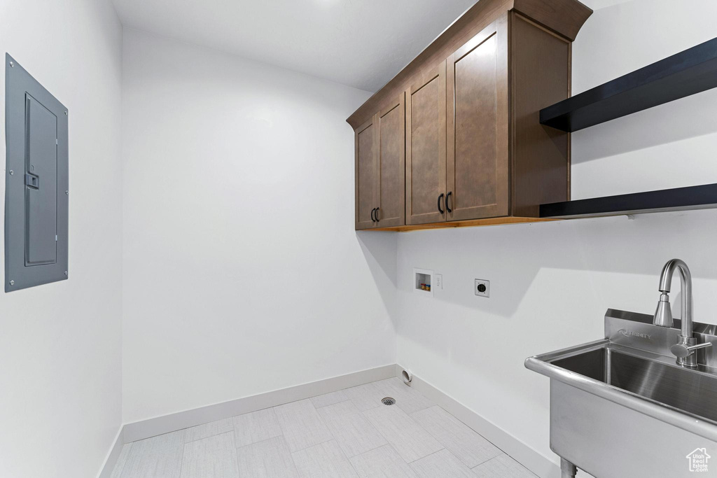 Laundry room featuring cabinets, washer hookup, electric dryer hookup, sink, and light tile flooring