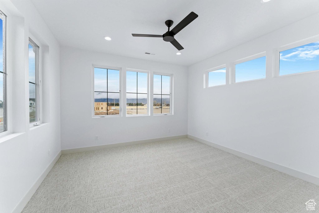 Empty room featuring ceiling fan and carpet floors