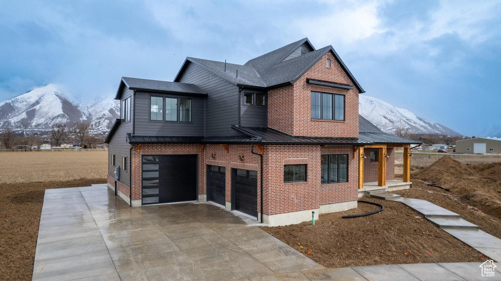 Rear view of house featuring a garage and a mountain view