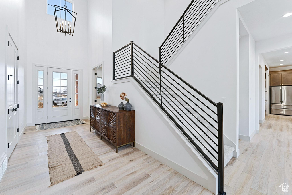 Entrance foyer with light hardwood / wood-style floors and a chandelier