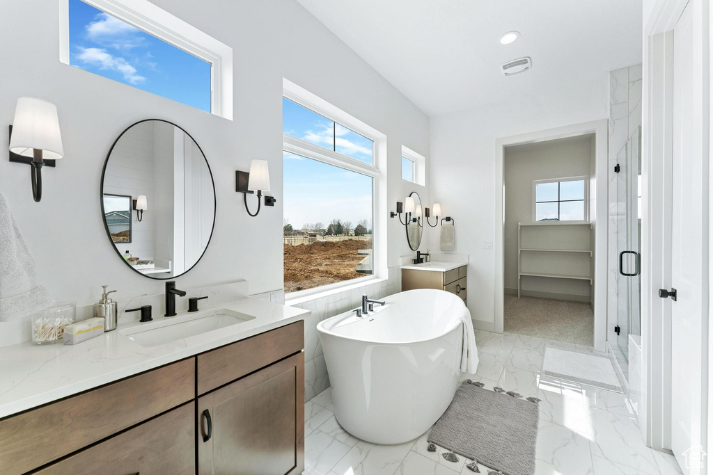 Bathroom with tile floors, plus walk in shower, a wealth of natural light, and vanity