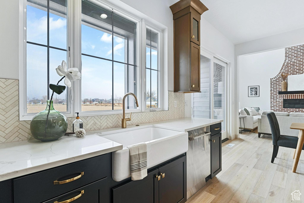 Kitchen with light hardwood / wood-style floors, a wealth of natural light, and backsplash