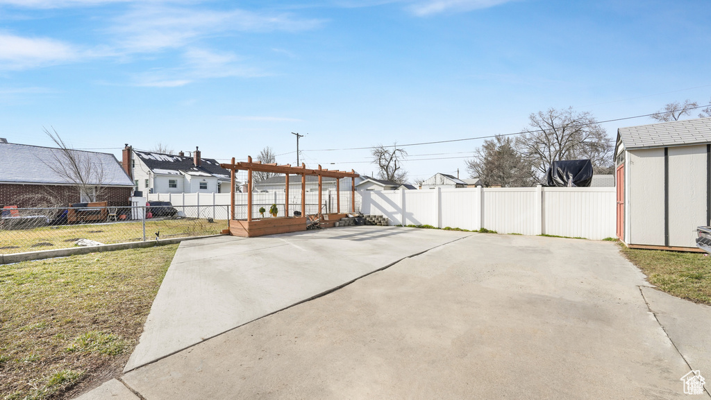 Exterior space with a shed, a lawn, and a patio