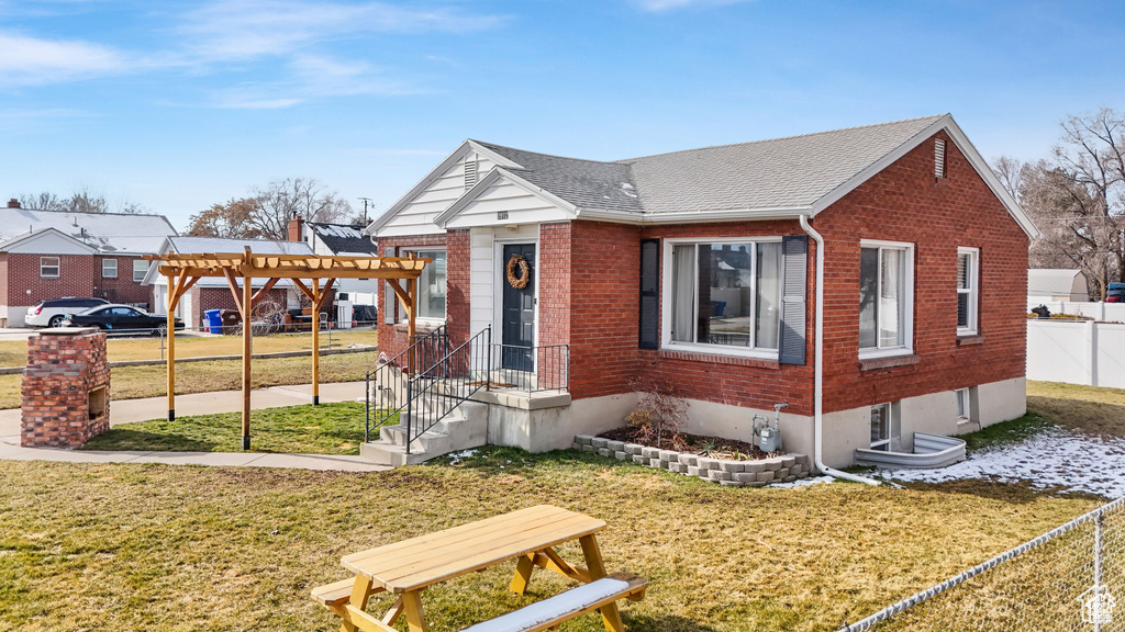 Bungalow-style house featuring a pergola and a front lawn