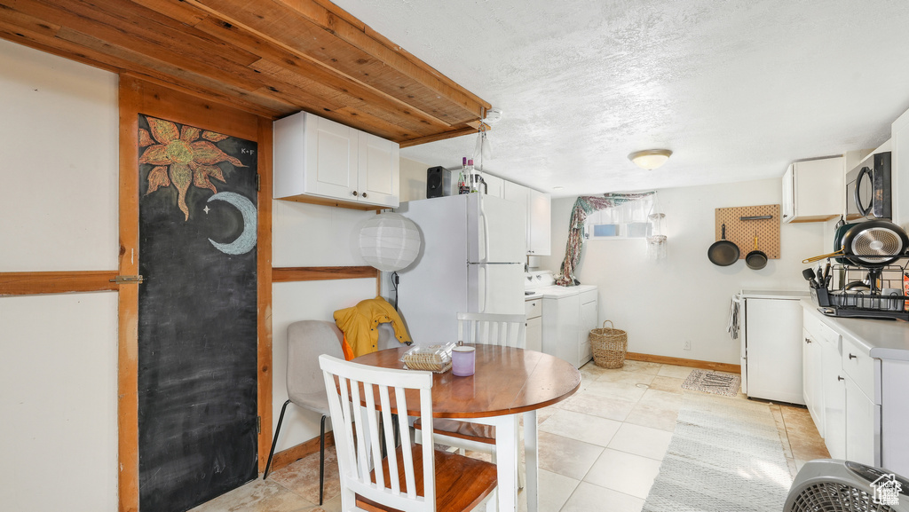 Tiled dining space featuring separate washer and dryer