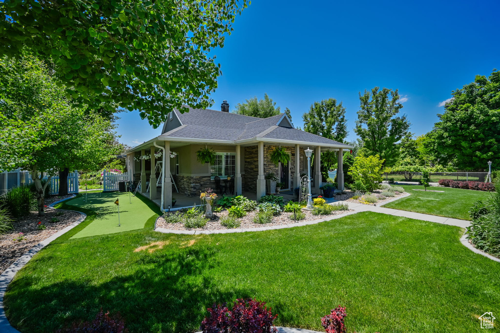 View of front of property with covered porch and a front lawn