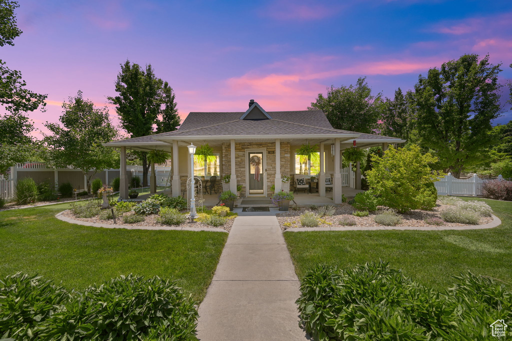 Farmhouse-style home featuring a yard and covered porch