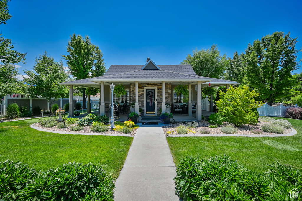 Farmhouse inspired home featuring a front lawn and a porch