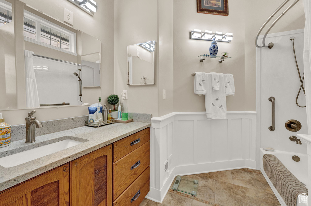 Bathroom with washtub / shower combination, tile flooring, and vanity