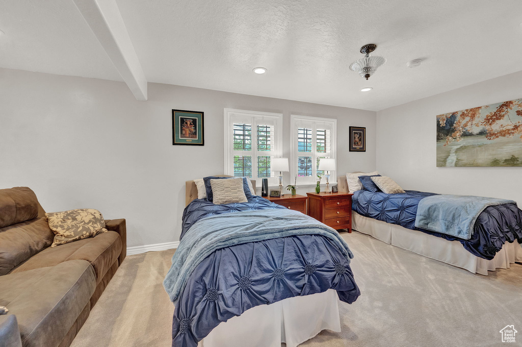 Bedroom featuring beam ceiling, a textured ceiling, and carpet flooring