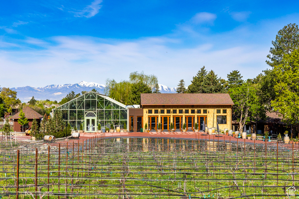 Back of property featuring a mountain view and a swimming pool