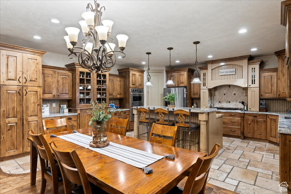 Dining area with a chandelier and light tile floors