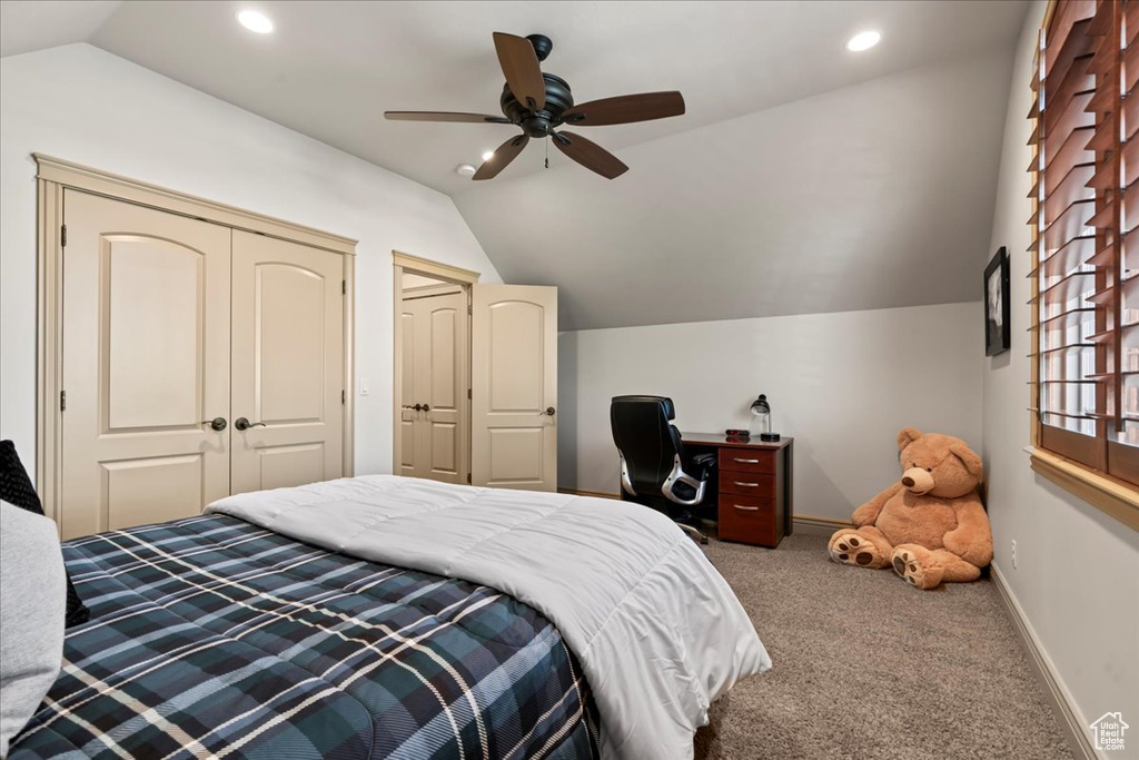 Carpeted bedroom with ceiling fan and vaulted ceiling