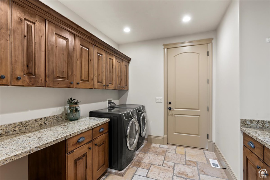 Clothes washing area with separate washer and dryer, washer hookup, light tile flooring, and cabinets