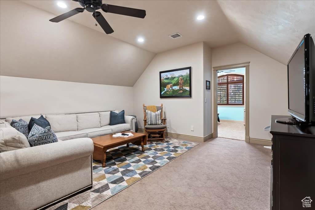 Living room featuring carpet, ceiling fan, and vaulted ceiling