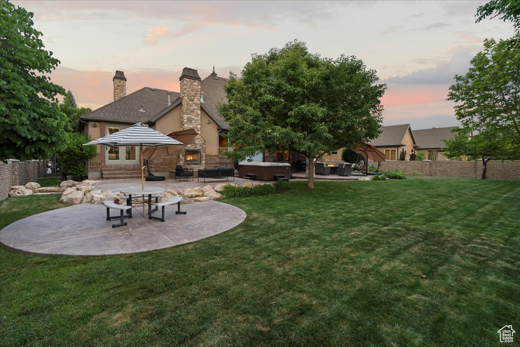 Yard at dusk featuring a patio area and an outdoor hangout area