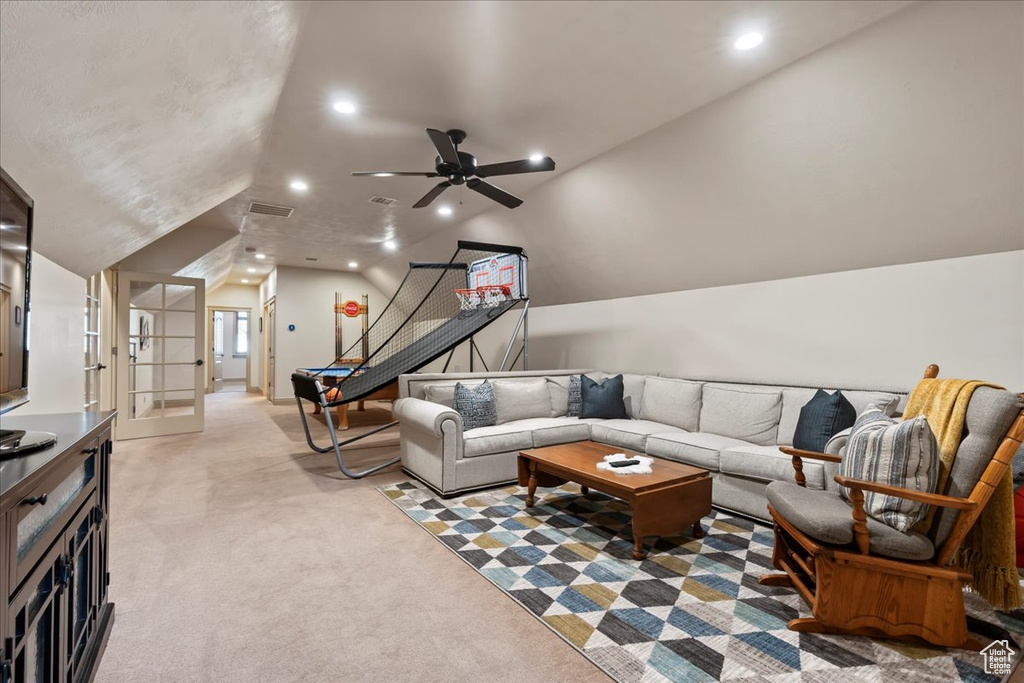 Carpeted living room featuring vaulted ceiling and ceiling fan