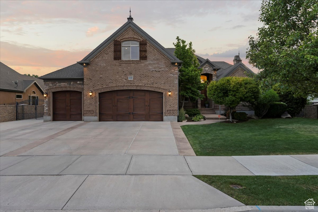 View of front of property featuring a garage and a lawn