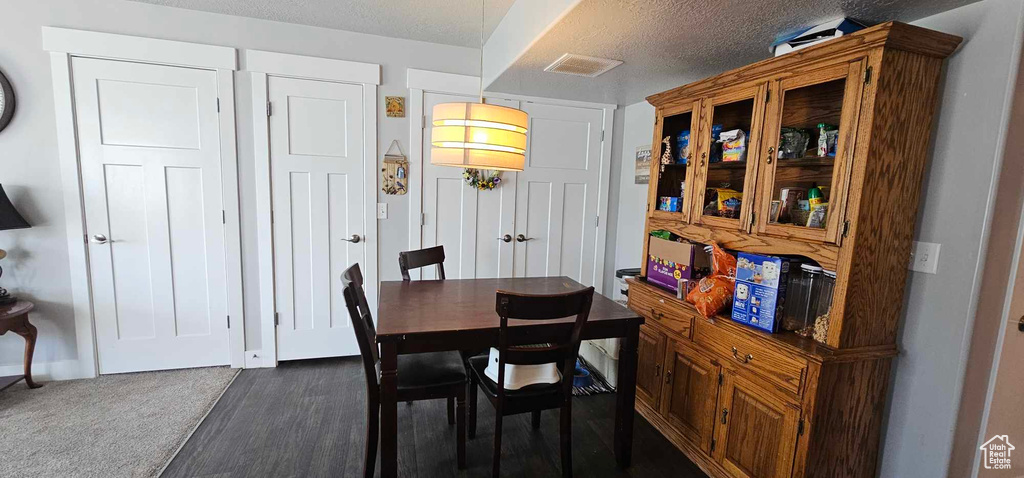 Carpeted dining space with a textured ceiling