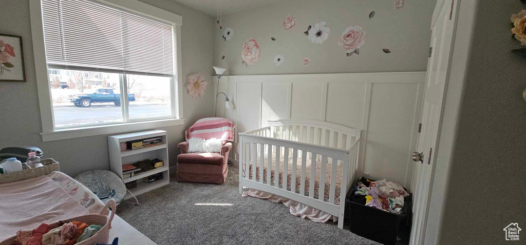 Carpeted bedroom featuring a nursery area