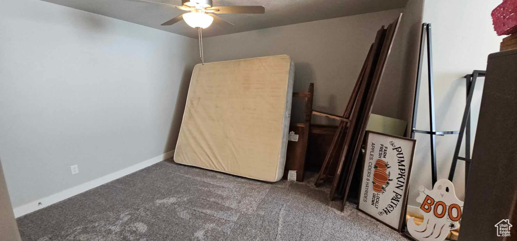 Unfurnished bedroom with ceiling fan and carpet flooring