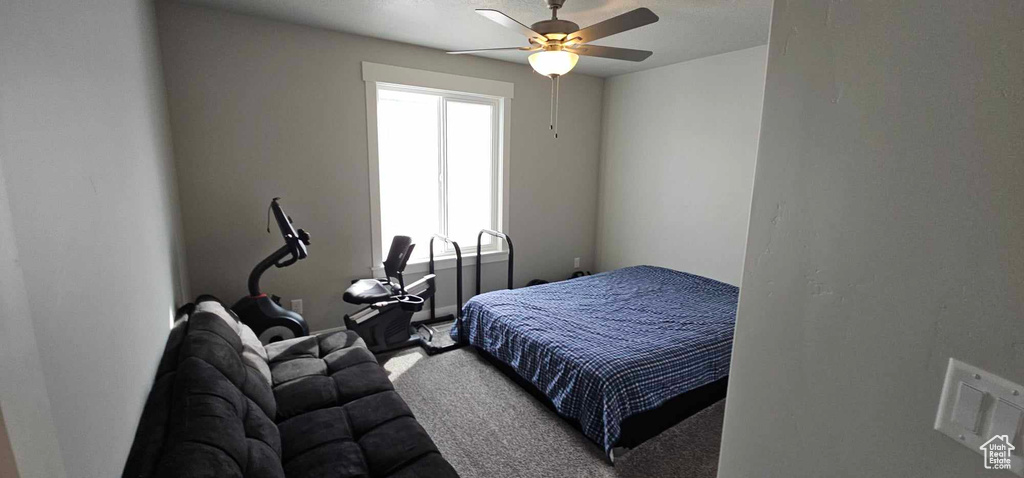 Carpeted bedroom featuring ceiling fan