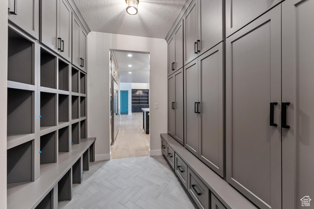 Mudroom with a textured ceiling and light parquet floors