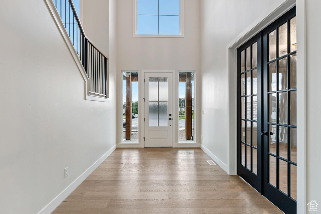 Entrance foyer with hardwood / wood-style flooring, a high ceiling, and french doors