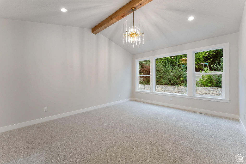 Unfurnished room featuring lofted ceiling with beams, carpet, and a healthy amount of sunlight