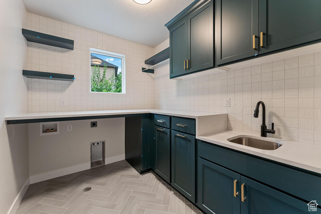 Kitchen with backsplash, sink, a textured ceiling, tile walls, and light tile patterned floors