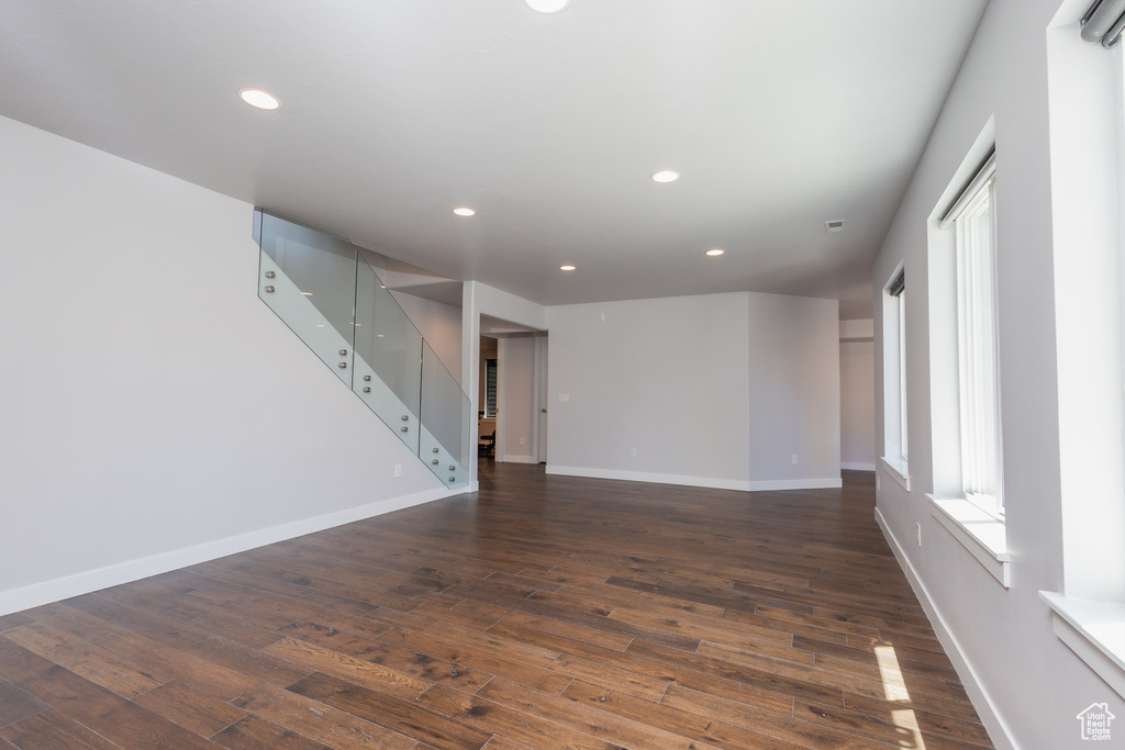 Unfurnished living room with dark wood-type flooring