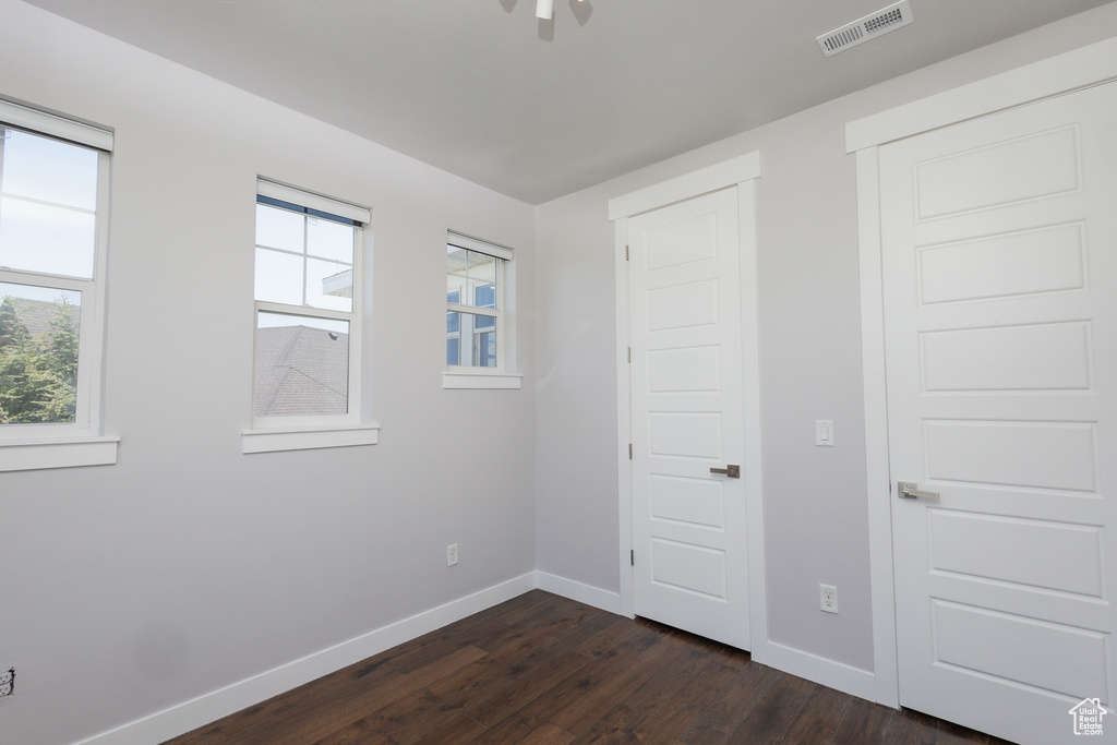 Unfurnished bedroom with dark hardwood / wood-style flooring