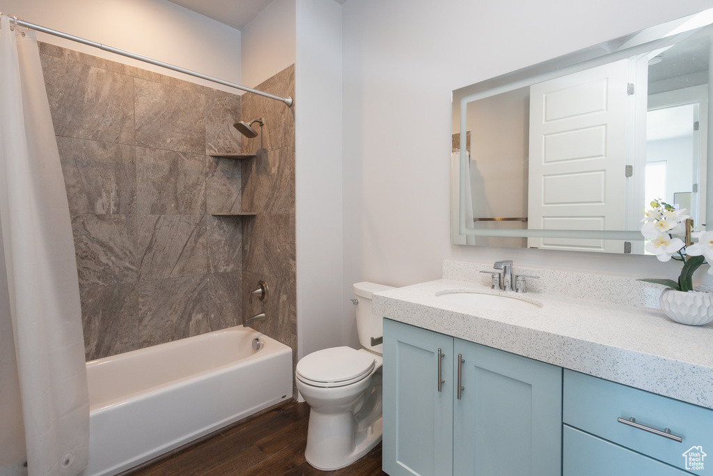 Full bathroom with shower / bath combo, hardwood / wood-style flooring, toilet, and vanity