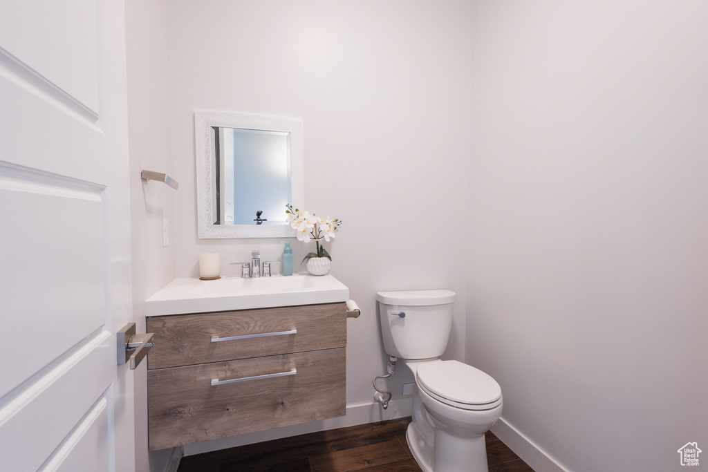 Bathroom featuring hardwood / wood-style flooring, vanity, and toilet