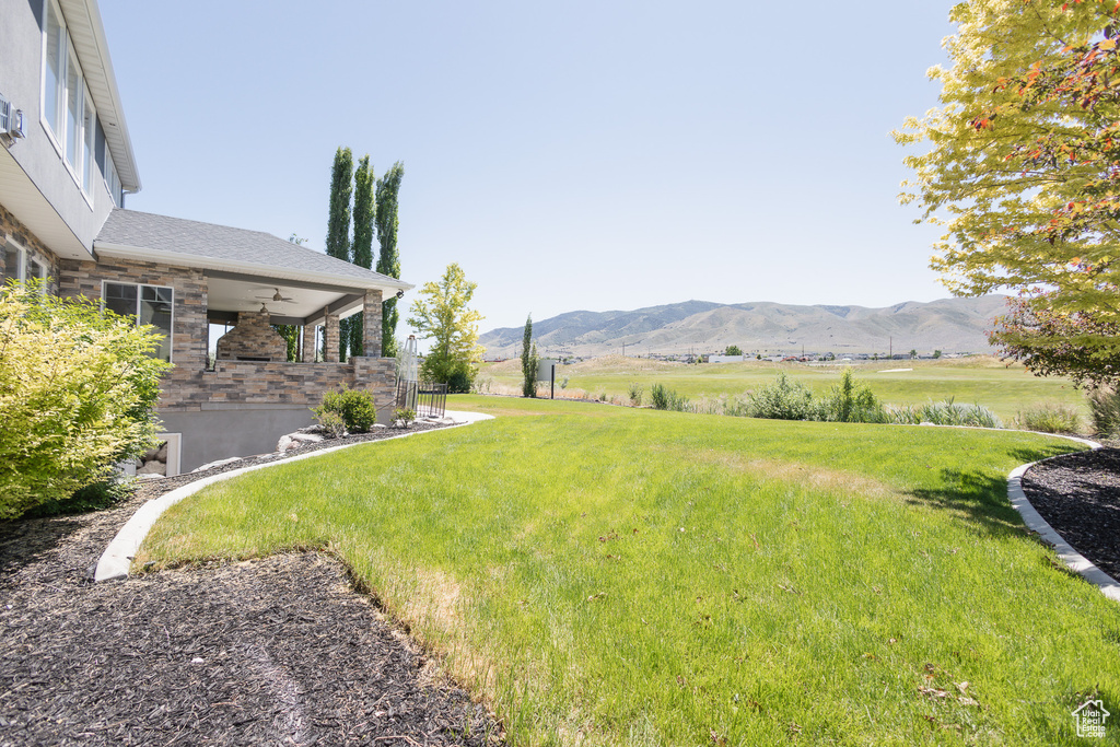 View of yard featuring a mountain view, ceiling fan, and a rural view