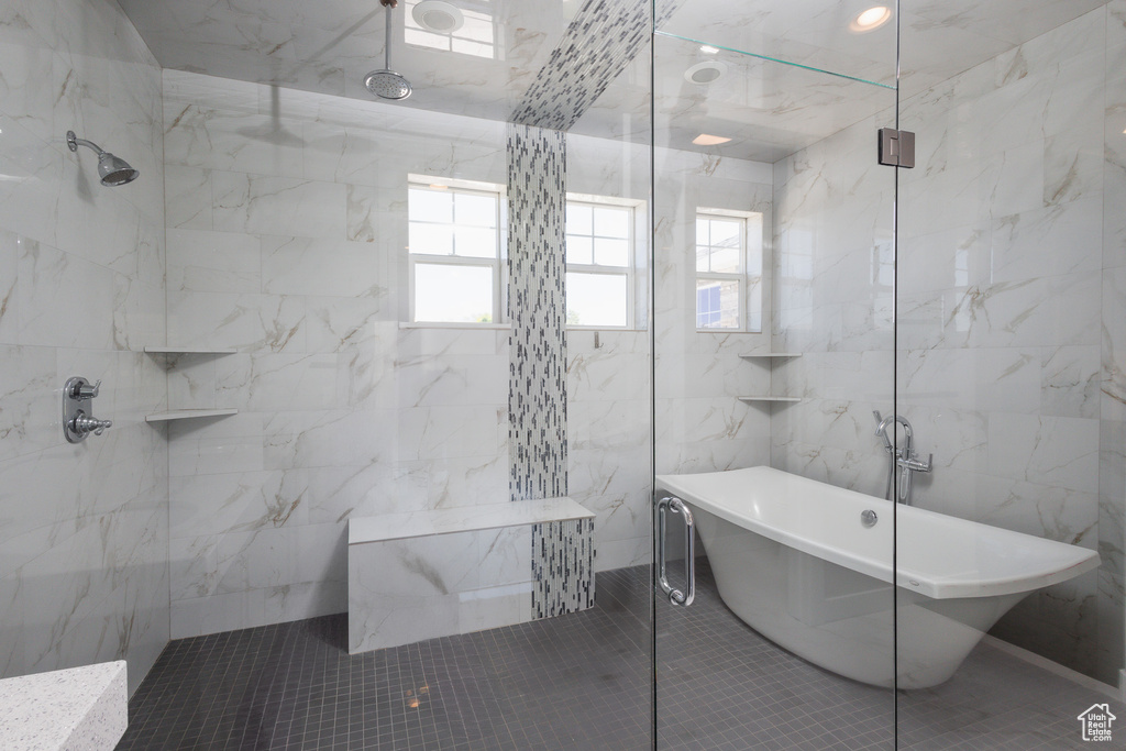 Bathroom with tile walls, tile floors, and shower with separate bathtub