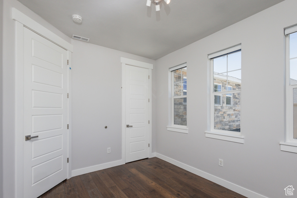 Empty room with dark hardwood / wood-style floors