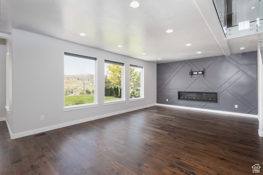 Unfurnished living room featuring dark hardwood / wood-style flooring and a fireplace